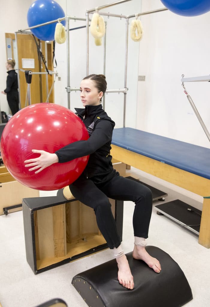 Royal ballet performer using an exercise ball as part of physiotherapy treatment.