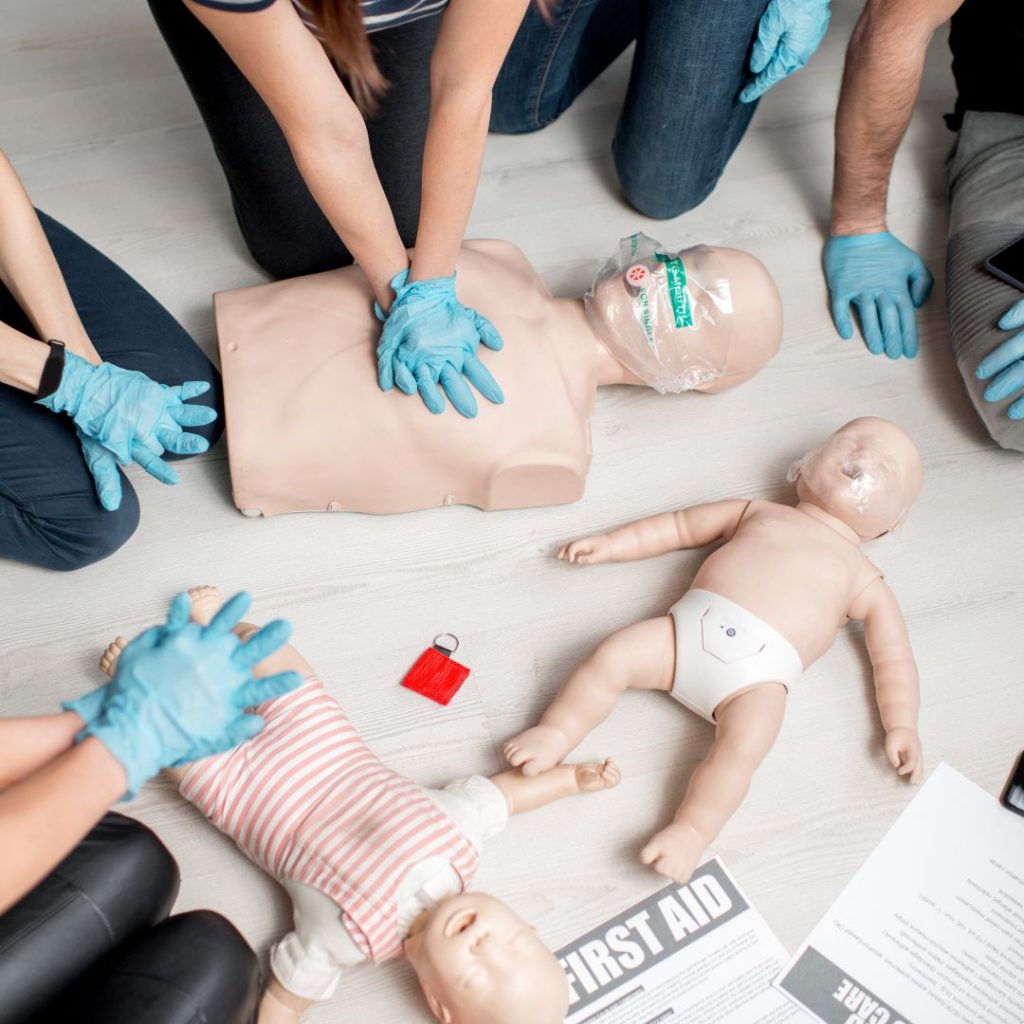A number of dental staff performing CPR on child & baby manikins