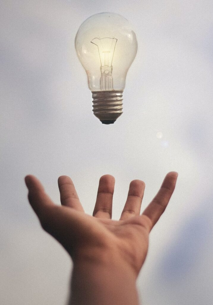 Open hand with lightbulb hovering above palm